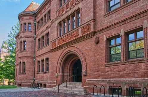Red brick university building with an arched entrance on a college campus